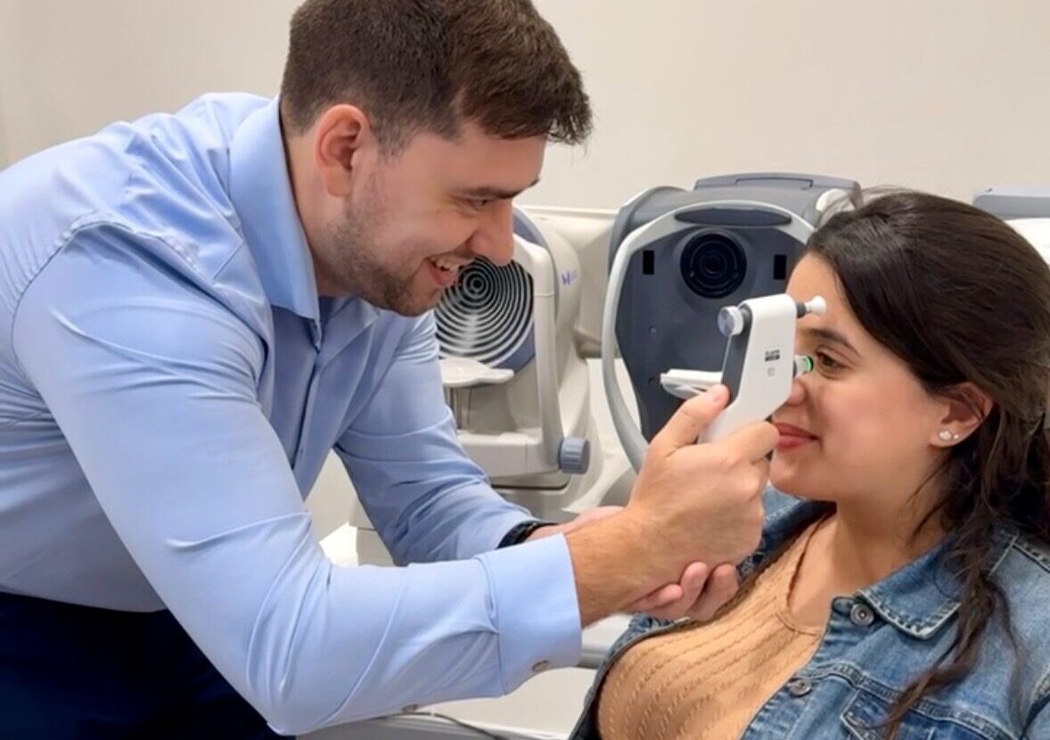 Dr. Rami Khaldieh performing a tonometry assessment on an adult woman to check eye pressure.